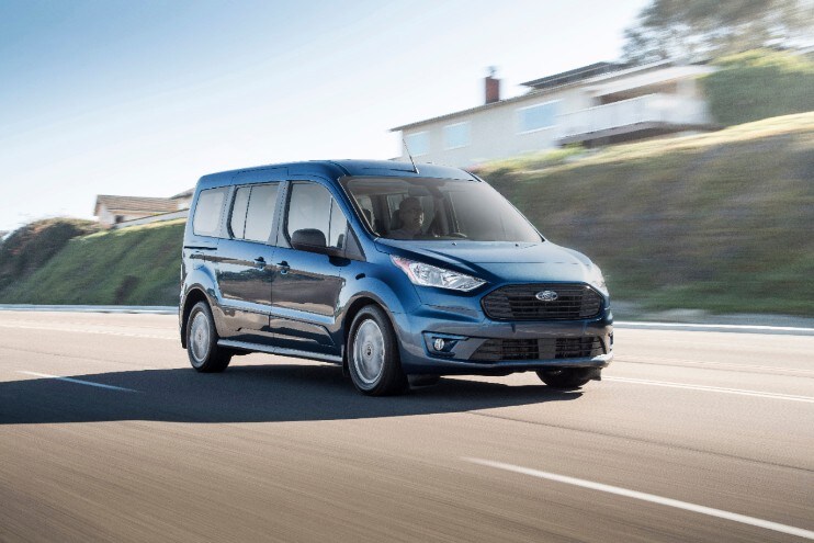 a blue transit connect passenger wagon driving