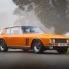 An orange 1969 Jensen Interceptor FF Mk I on a foggy countryside road