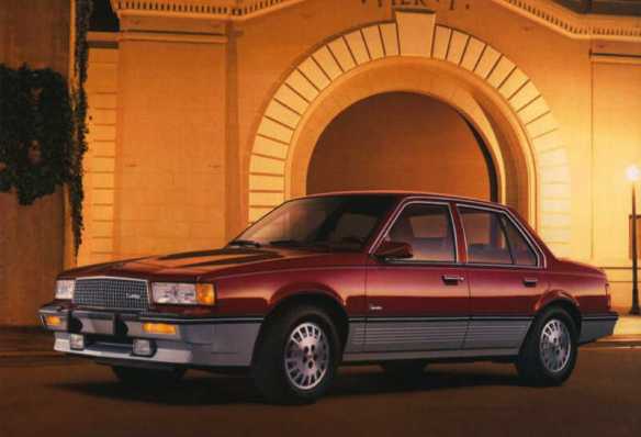 red and silver Cadillac Cimarron with orange background