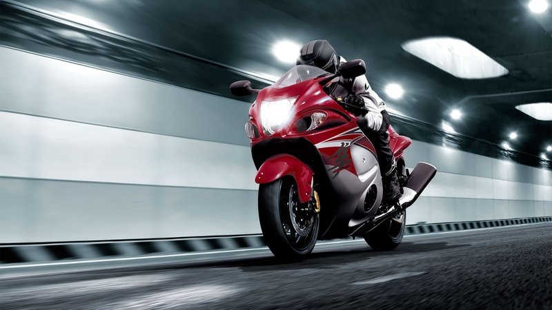 A red Hayabusa motorcycle speeding through a tunnel