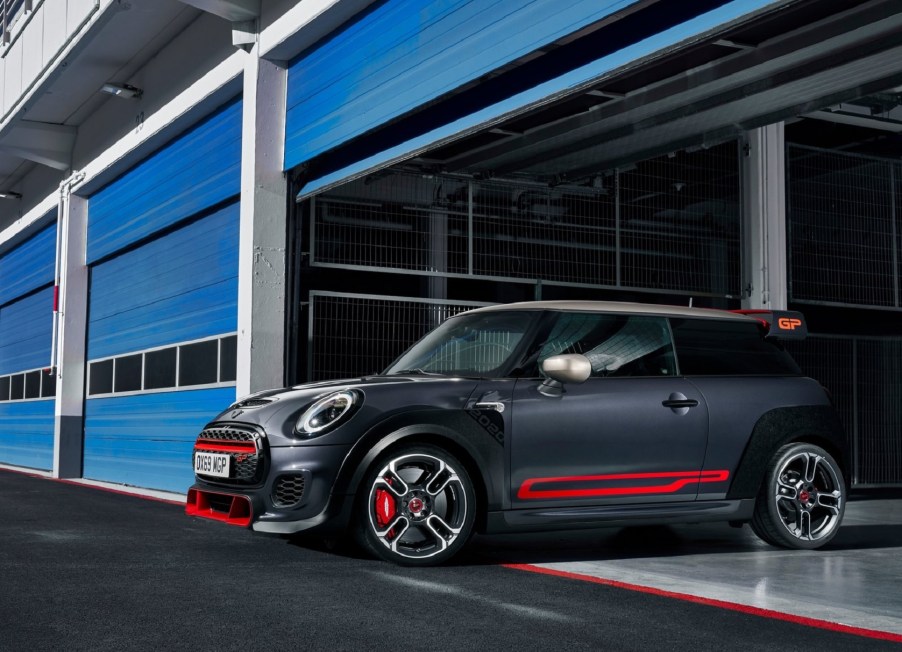 A black-and-red 2020 Mini Cooper JCW GP coming out of a blue track-side garage