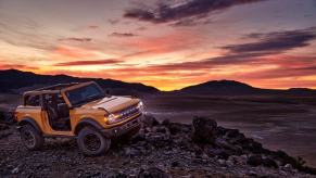 yellow 2021 Ford Bronco with front roof and doors removed bombing through the desert