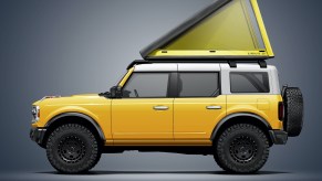 A yellow 4-door 2021 Ford Bronco with a Go Fast Campers SuperLite rooftop tent