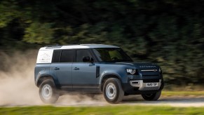 Blue 2021 Land Rover Defender Hard Top 110 panel van driving down a country road