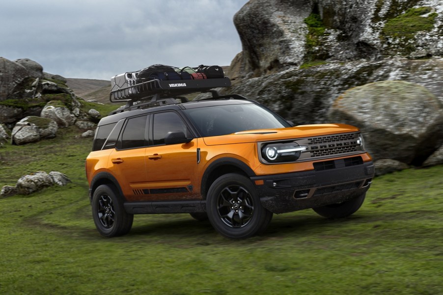 The 2021 Ford Bronco, the SUV sibling of the Ford F-150, in cyber orange off-roading in the wilderness