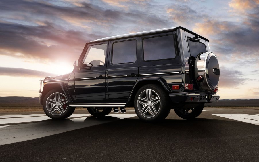 A black 2014 G-Class SUV parked near the countryside.