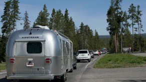 An Airstream RV trailer along with others, wait in a long line to enter the south entrance to Yellowstone National Park