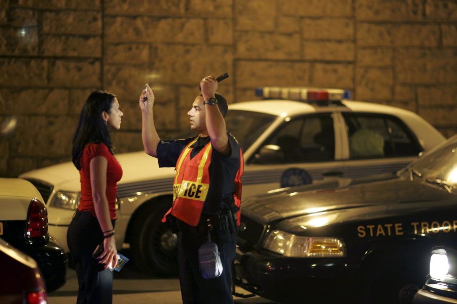 A police officer preforms a DUI test on a woman