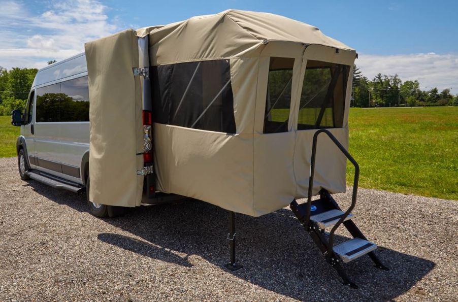 The rear of an RV has a porch tent platform.