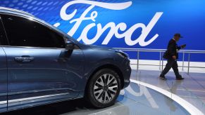 A visitor walks past a Ford Escape Titanium at the Shanghai Auto Show