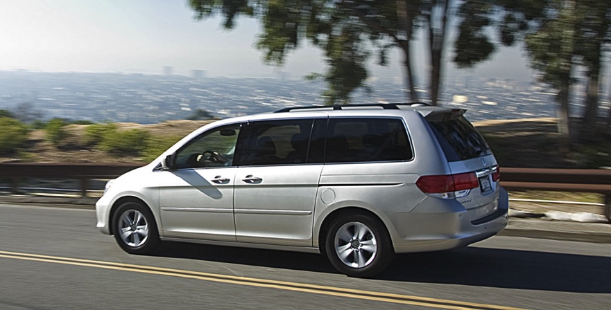 2008 silver Honda Odyssey driving on a scenic road