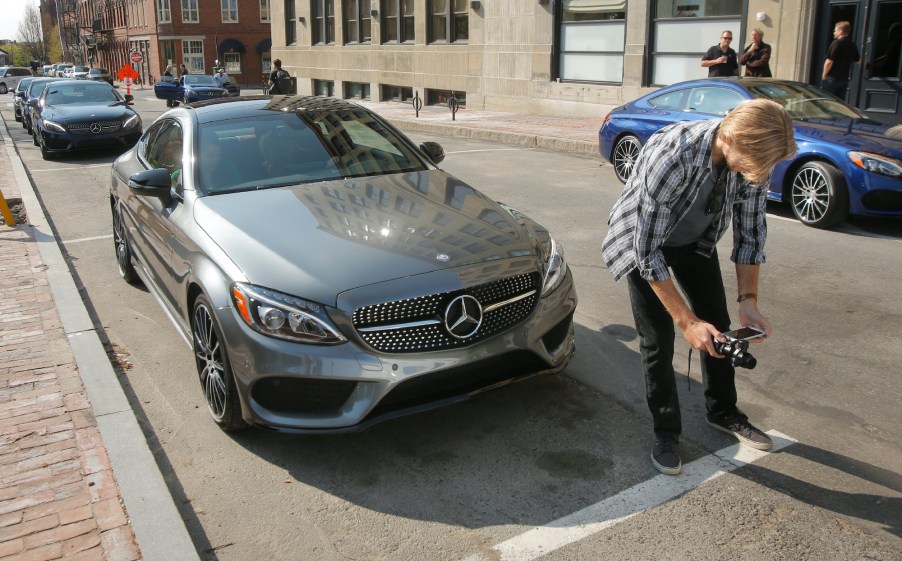 Greg Carloss [cq] of Baltimore shoots video of a Mercedes C300 coupe on Market Street