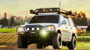 A white modified 2005 Lexus LX470 in a country field