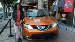 A woman standing next to a Nissan Rogue