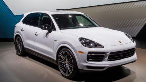 A white Porsche Cayenne Hybrid on display at an auto show