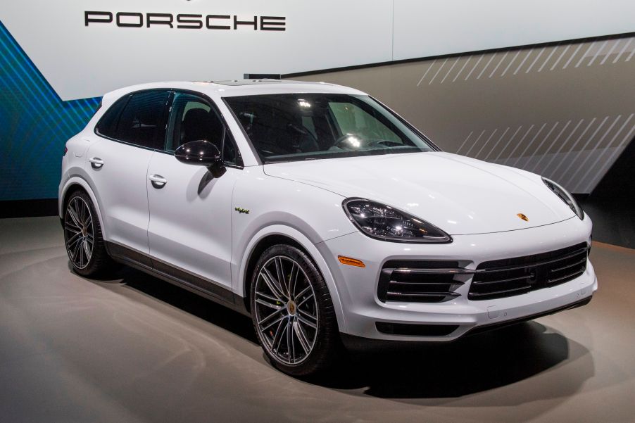 A white Porsche Cayenne Hybrid on display at an auto show