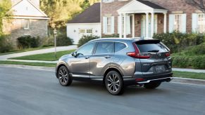 a side rear view of the cr-v in motion on a suburban road