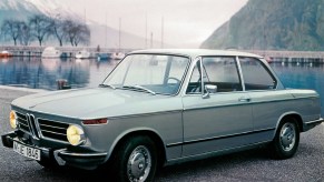 A light-blue 1968 BMW 2002 at a pier