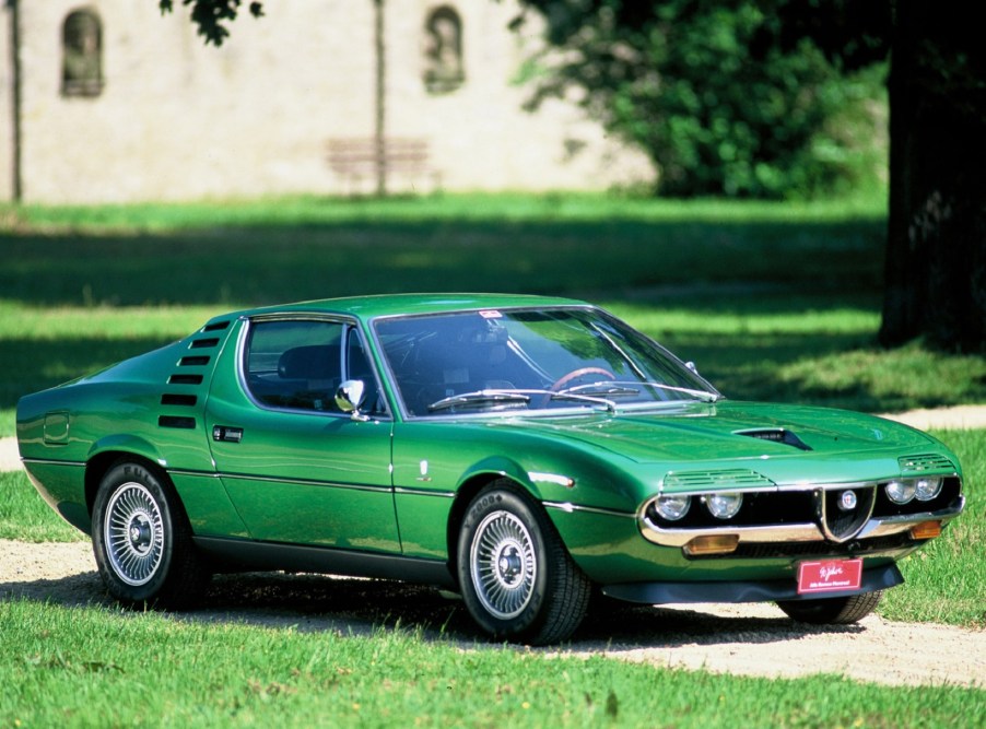 A green 1970 Alfa Romeo Montreal on a manicured estate lawn