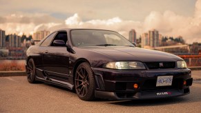 A purple 1995 R33 Nissan Skyline GTR V-Spec parked on a dock