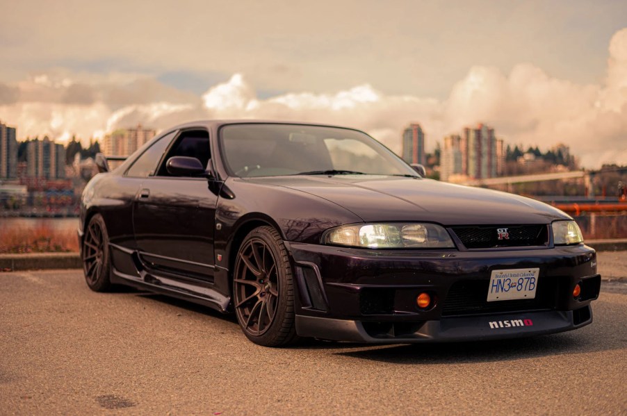 A purple 1995 R33 Nissan Skyline GTR V-Spec parked on a dock