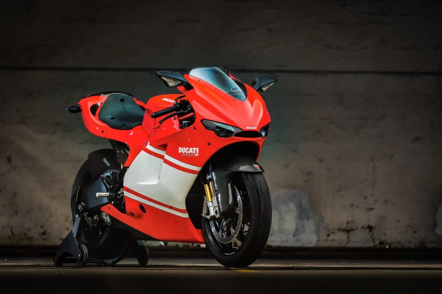 A red-with-white-stripe 2008 Ducati Desmosedici RR on a rear wheel stand