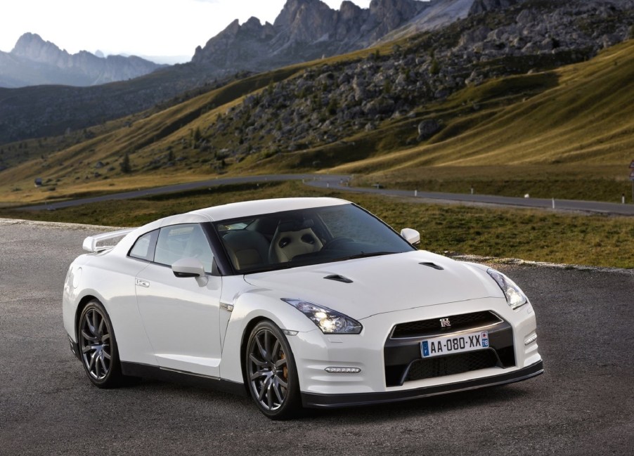 A white 2011 Nissan GT-R in green rolling rocky hills