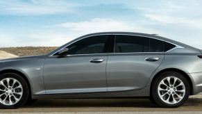 A charcoal colored Cadillac CT5 sedan on a desert road.