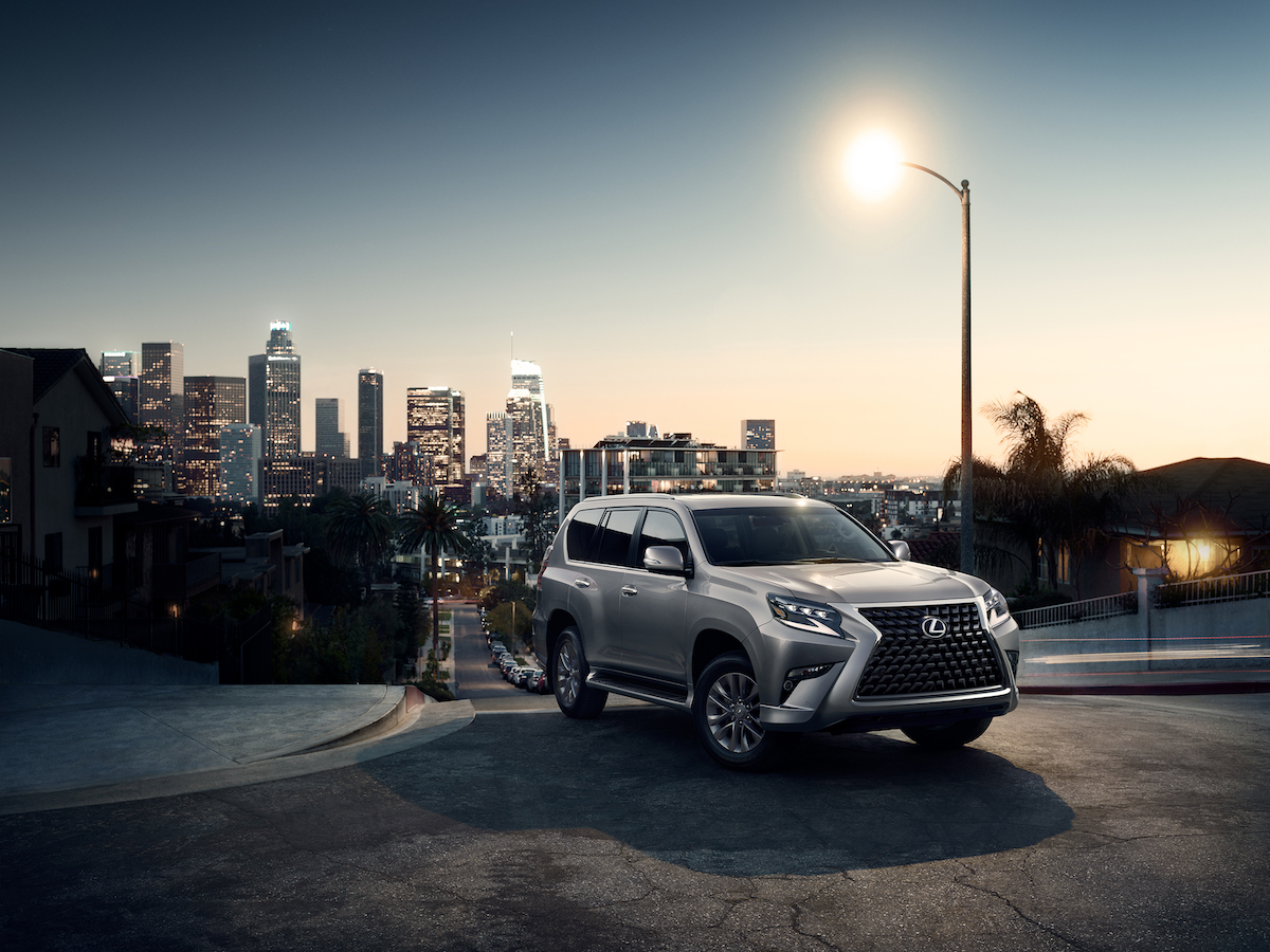 2020 Lexus GX driving away from the city skyline