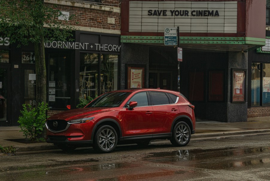 A red 2020 Mazda CX-5 Signature AWD on a rainy city street