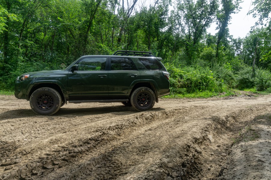 A green 2020 Toyota 4Runner TRD Pro on a rutted muddy forested off-road trail