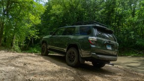 A rear shot of a green 2020 Toyota 4Runner TRD Pro on a forest off-road trail near a creek