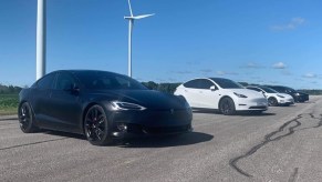 The 2021 Tesla Performance lineup, with a black Model S in front of a white Model Y in front of a white Model 3 in front of a black Model X