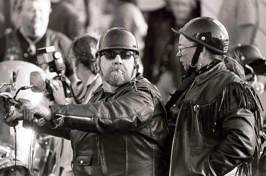 A biker couple wearing black leather motorcycle jackets