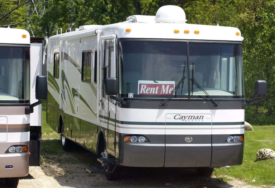 A camper with a rental sign in the windshield