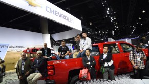 Attendees sit in the bed of a 2015 Silverado 2500 HD as they listen to the Chevrolet press conference, at the Los Angeles Auto Show