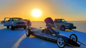 The Electraline Lakester electric vehicle is in the foreground of the Bonneville Salt Flats, with the sunrise in the distance.