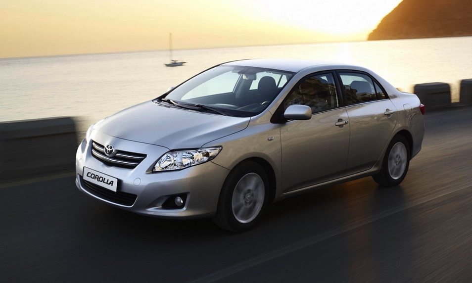 a silver 2007 Toyota Corolla driving at speed on a city street