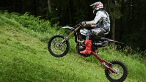 A black Indian FTR750 hill climb bike speeds up a grassy hill