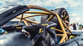 Black Momo racing seats with harnesses in a BMW E30 M3 with a gold roll cage