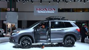 A woman checks out the drivers side of a 2019 Honda Passport AWD Elite on display at AutoMobility LA