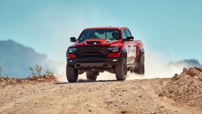 a red Ram 1500 TRX at speed on a dusty desert trail