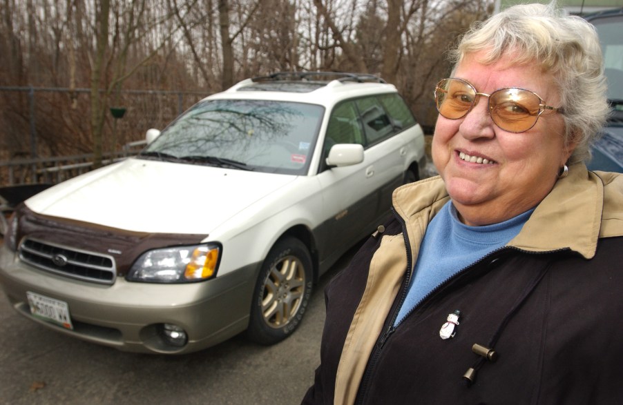 A woman posing for a photo with her Subaru Outback SUV