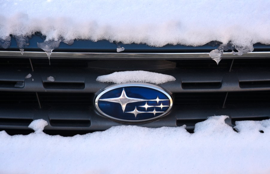 The Subaru logo attached to the grill of a snow-covered Subaru Outback in New Mexico.