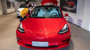 People look at a Tesla Model 3 car at the first Tesla Center in Shanghai