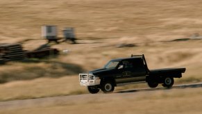 old ram ranch truck at speed on a dirt ranch road