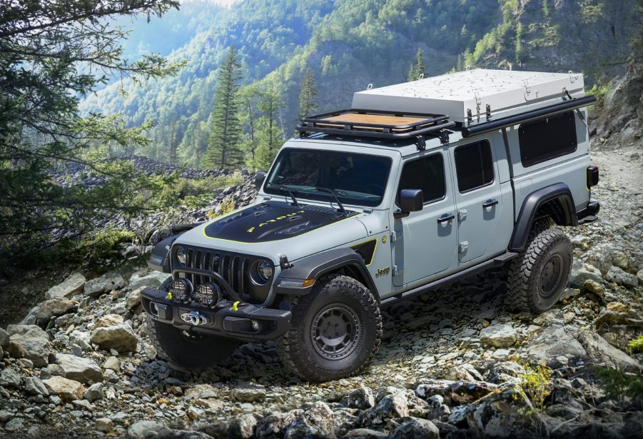 A gray Jeep Gladiator pickup is going down a trail road.