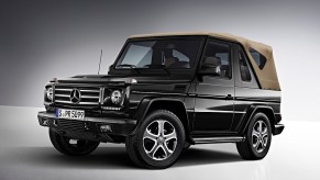 a black cabriolet g-wagon with a tan convertible top, press phot against a gray backdrop