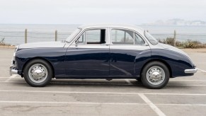 The side view of a blue-and-silver 1958 MG Magnette ZB Varitone by the sea