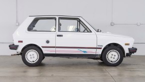 A small, white, hatchback profile-view of the Yugo.